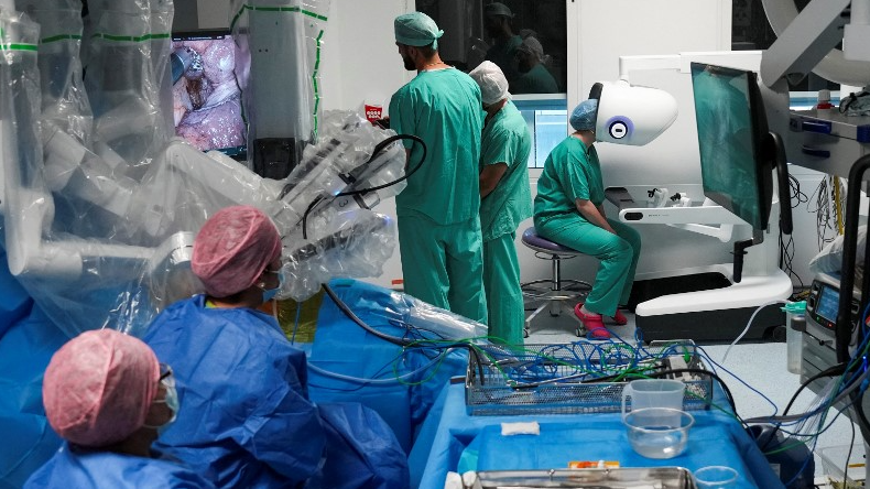 Chirurgiens et infirmières utilisant le nouveau système chirurgical assisté par robot Da Vinci 5 lors d'opérations chirurgicales, à l'hôpital St Bartholomew de Londres. /Carlos Jasso/AFP