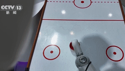 Un robot jouant un défi de hockey sur air avec son rival humain. /CMG