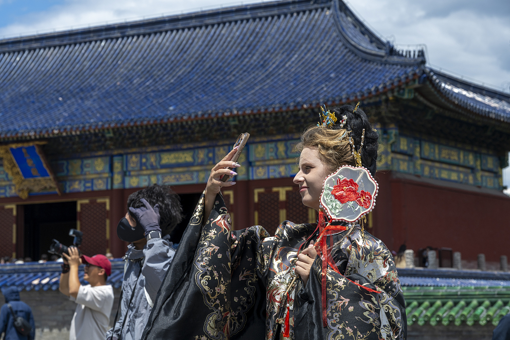 Un touriste étranger prend des photos dans le Temple du Ciel à Pékin, en Chine, le 9 juin 2026. /VCG