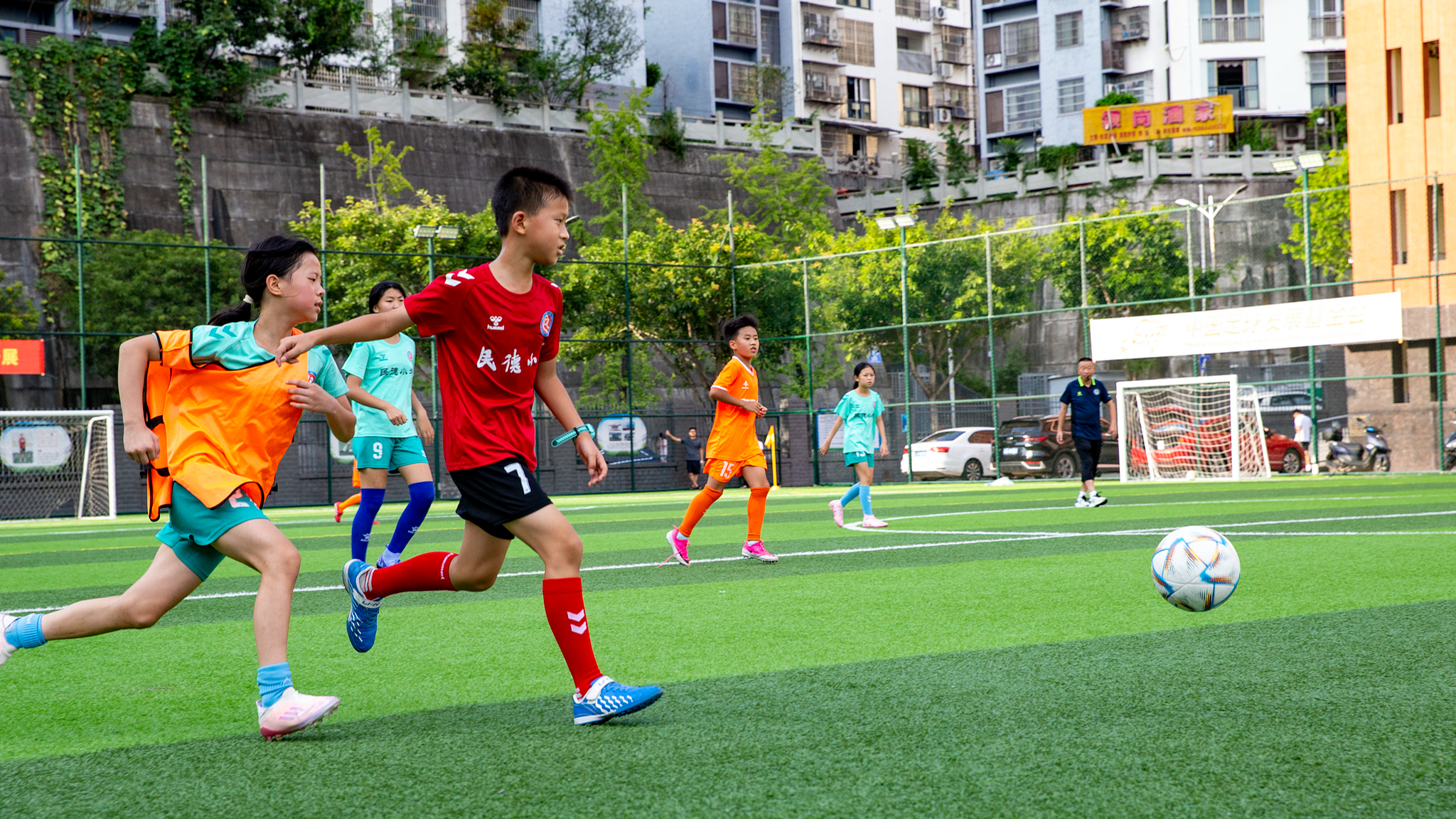 Un groupe de plus de 200 adolescents participent à un camp d'été de football pour jeunes dans le comté de Yunyang, municipalité de Chongqing, dans le sud-ouest de la Chine, le 21 août 2026. /VCG