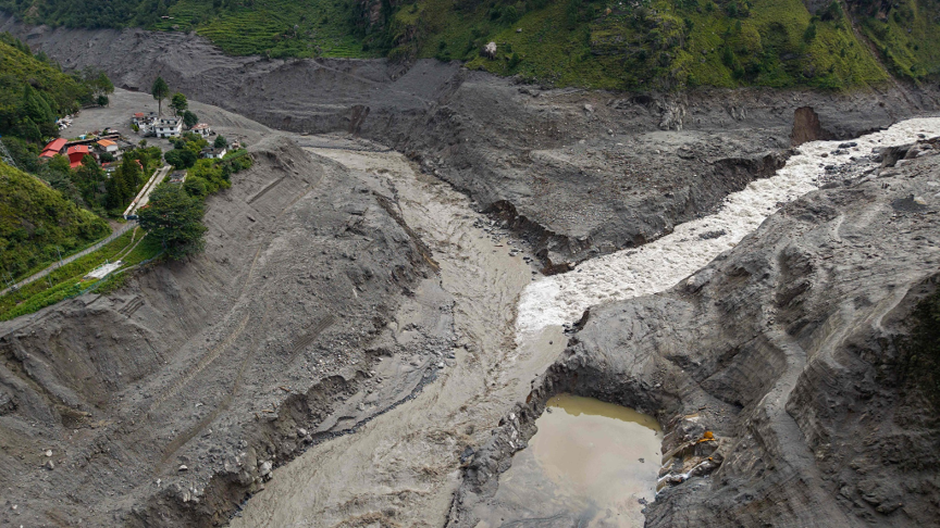 Une vue aérienne montre un torrent d'eau boueuse déferlant devant les maisons et traversant la rivière Trishuli à la suite d'inondations soudaines près de la frontière entre le Népal et la Chine, dans le village de Syabrubesi, dans le district de Rasuwa au Népal, le 31 août 2026. /AFP