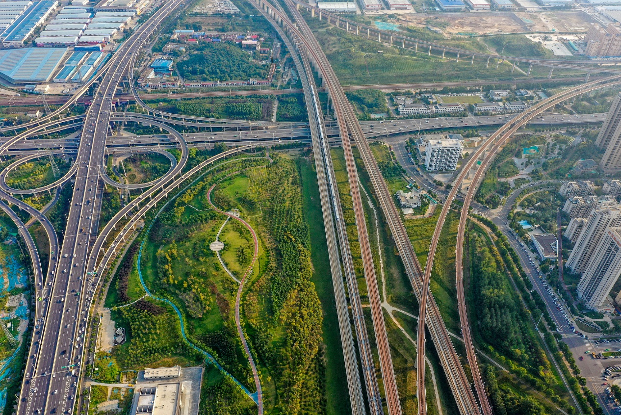 Des trains à grande vitesse circulent dans la verdure de la nouvelle zone de Zhengdong à Zhengzhou, province du Henan, en Chine, le 17 juin 2026. /VCG