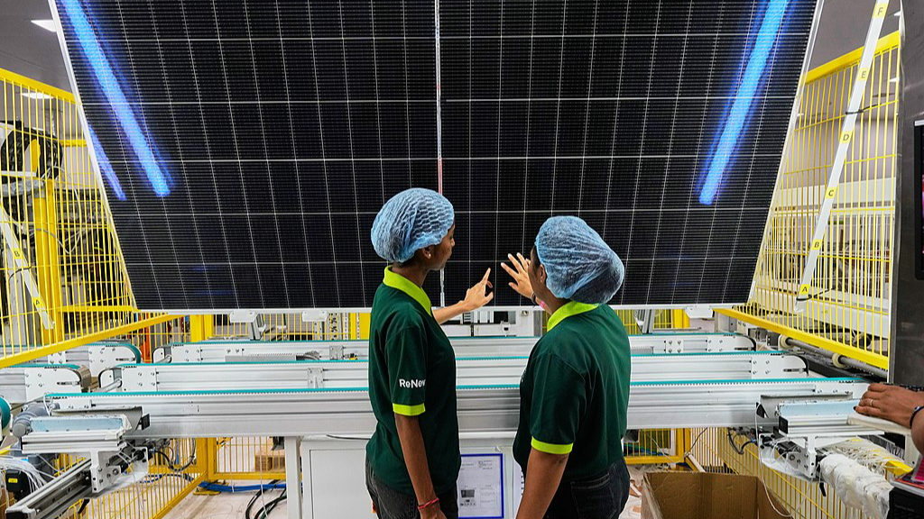 Des ouvriers vérifient la qualité d'un panneau solaire sur la chaîne de production de l'usine de fabrication de panneaux solaires ReNew, dans la banlieue de Jaipur, en Inde, le 21 août 2026./VCG 