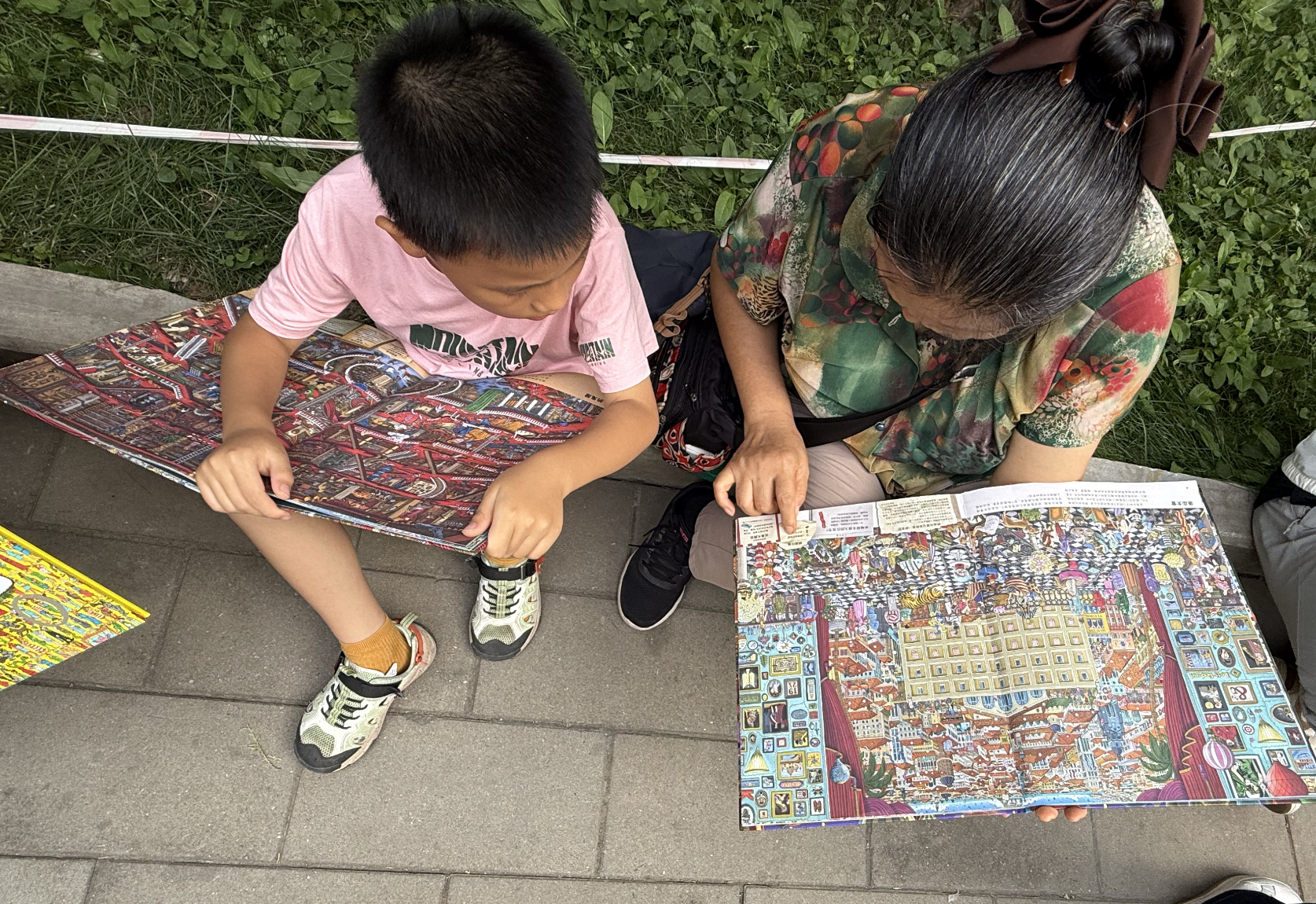 Visiteurs assis sur le trottoir pour lire les livres nouvellement achetés à la Foire du livre Ditan 2026, 19 septembre 2026, Zaruhi Poghosyan /CGTN