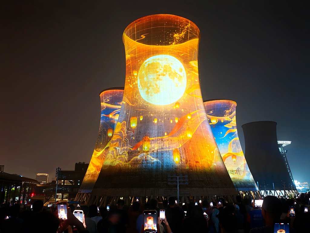 Le parc Shougang, une ancienne aciérie devenue un monument culturel et de loisirs, est illuminé tandis que les visiteurs admirent la lune et les lanternes pour célébrer la fête de la mi-automne, à Pékin, capitale de la Chine, le 25 septembre 2026. /VCG