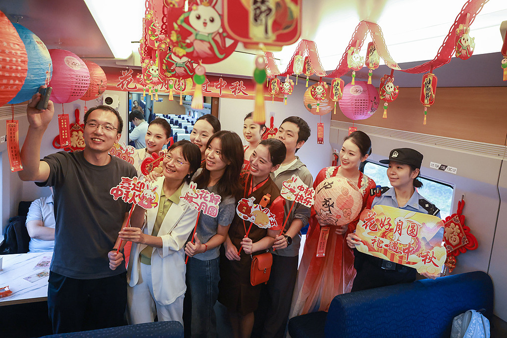 Le personnel du train et les passagers participent à un événement sur le thème de la fête de la mi-automne célébrant les retrouvailles à bord d'un train reliant la gare de Hankou à la gare de Yichang Est, le 23 septembre 2026. /VCG
