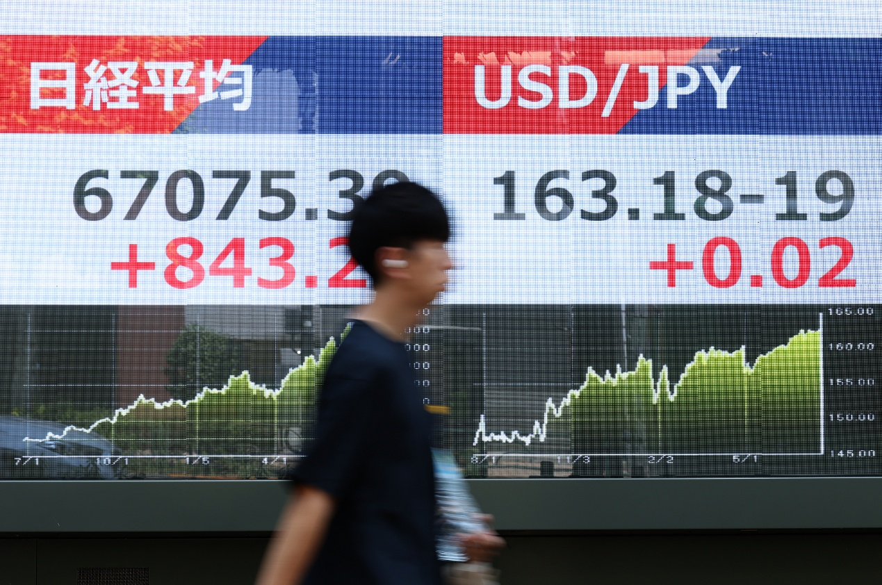 L'indice Nikkei 225 et le taux du yen par rapport au dollar américain affichés devant une maison de titres à Tokyo, au Japon, le 22 juillet 2026. /VCG