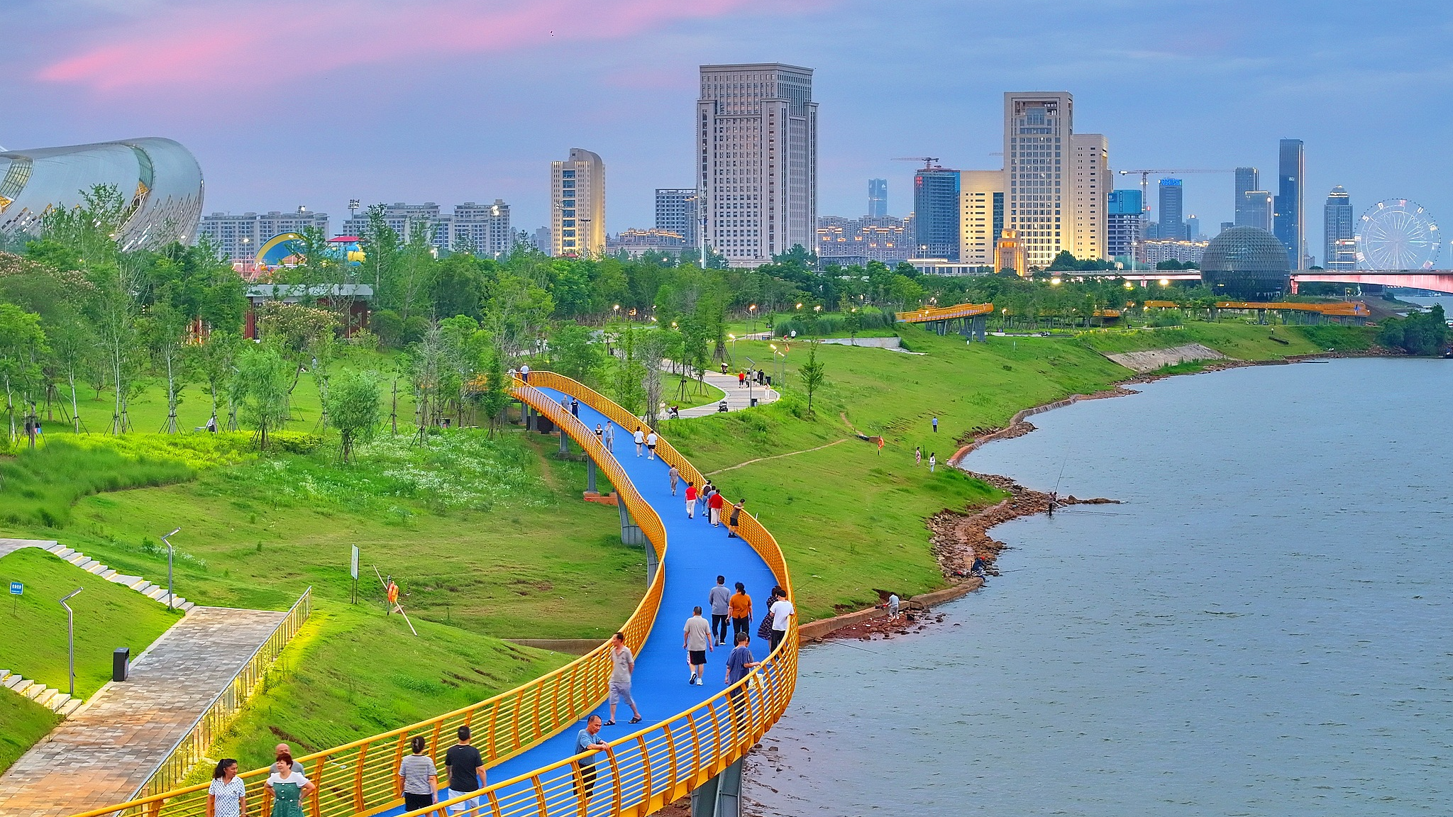 Des résidents faisant de l'exercice au parc citoyen de Ganjiang, dans le district de Honggutan, à Nanchang, dans la province du Jiangxi (est de la Chine), le 14 juin 2025. /VCG