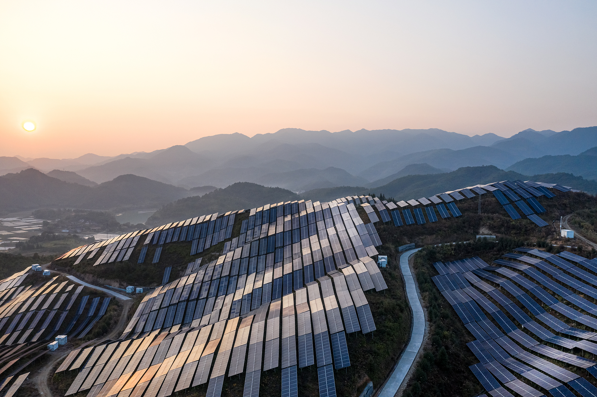 Une photo d’archive montre une vue aérienne d’une centrale solaire au coucher du soleil dans une zone montagneuse. /CFP