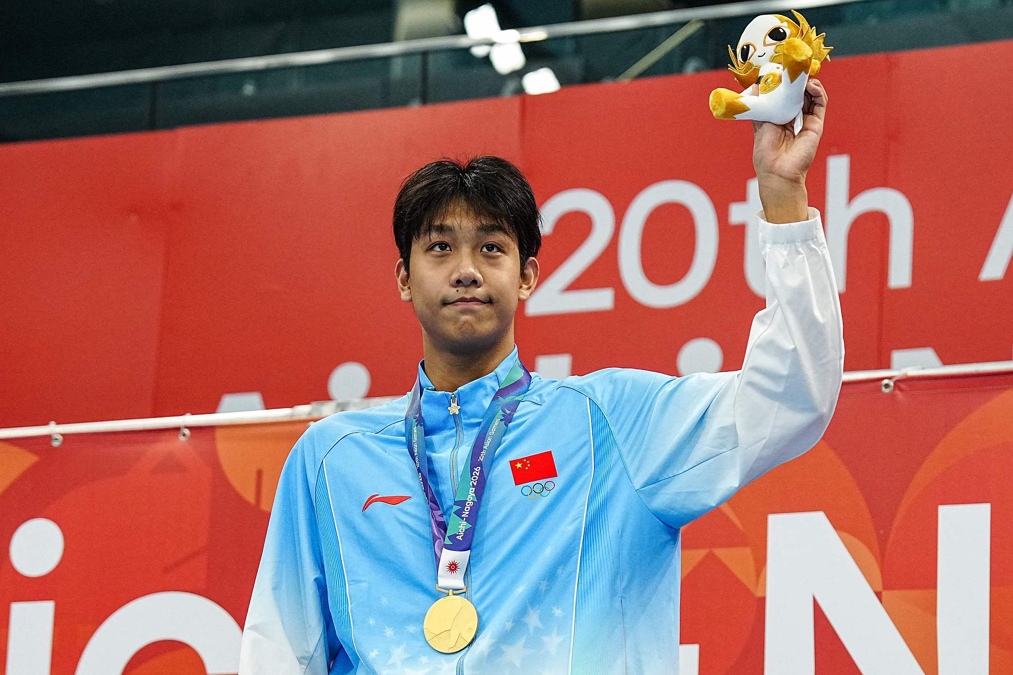 Le médaillé d'or chinois Zhang Zhanshuo célèbre sur le podium lors de la cérémonie de victoire du 1 500 m nage libre masculin lors des Jeux asiatiques au Centre aquatique de Tokyo, au Japon, le 22 septembre 2026. /VCG
