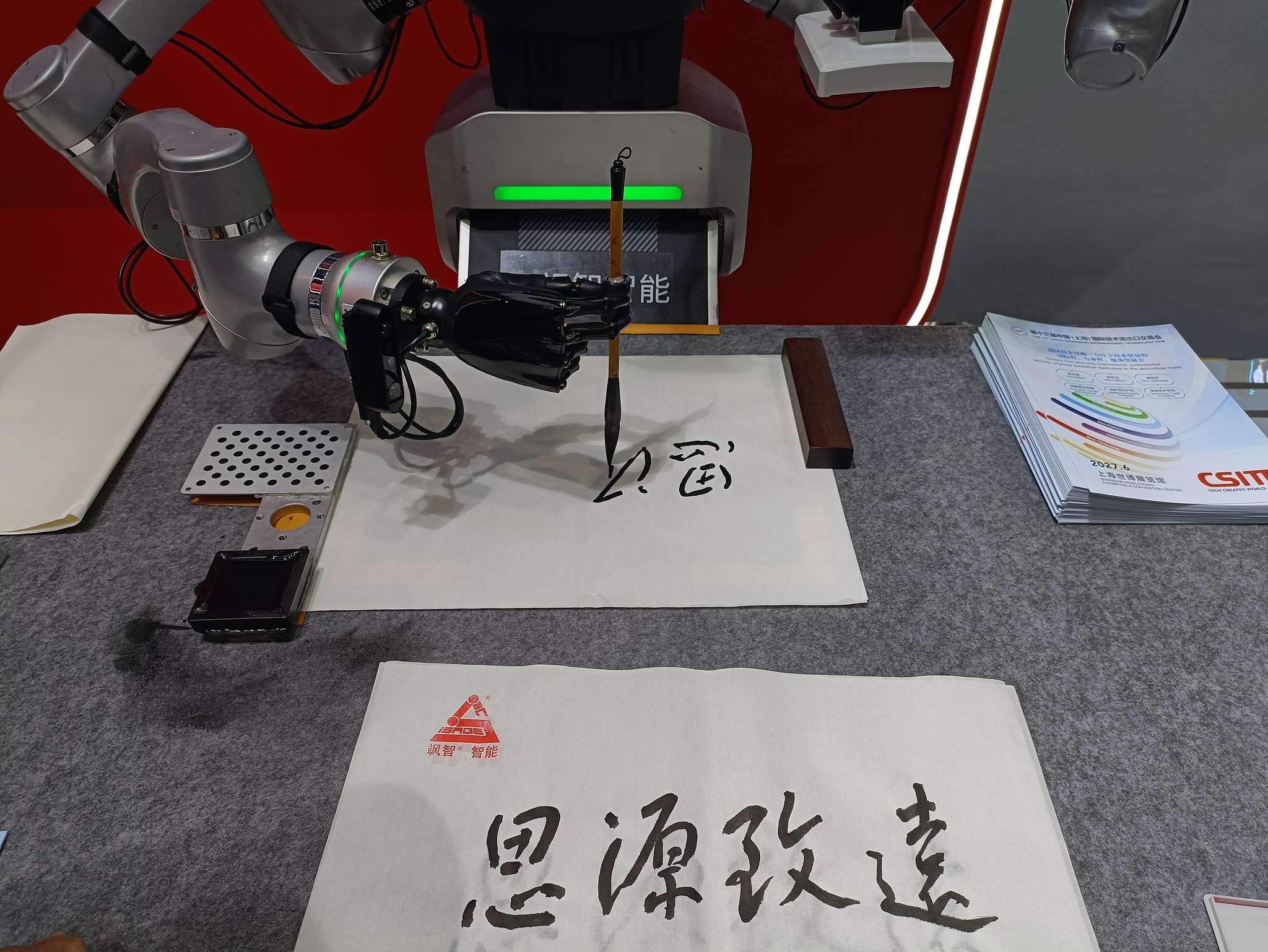 Un robot de SaZhi Intelligence présente la calligraphie chinoise sur le stand d'exposition de Shanghai de la Foire internationale du commerce des services de Chine 2026 à Pékin, le 10 septembre 2026. /VCG