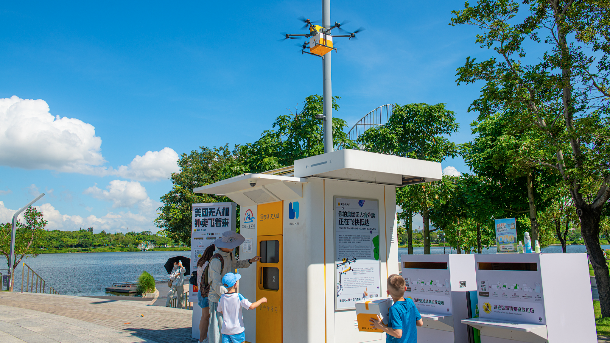 Des visiteurs étrangers testent le service de livraison de nourriture par drone dans un parc de Shenzhen, dans la province du Guangdong (sud de la Chine), le 21 juin 2026. /VCG