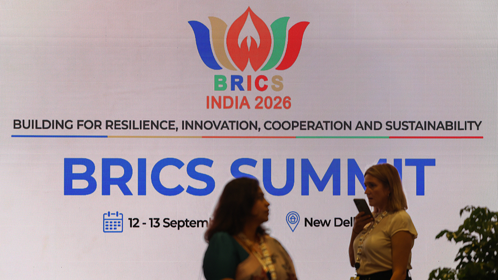 Des gens passent devant la signalisation des BRICS à Bharat Mandapam, lieu du sommet des BRICS 2026, à New Delhi, en Inde, le 12 septembre 2026. /VCG