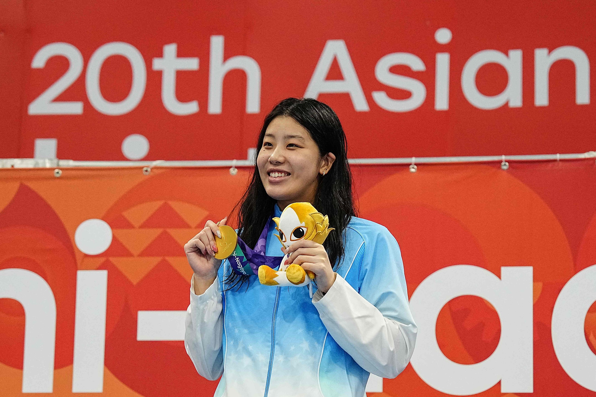 La Chinoise Wu Qingfeng affiche sa médaille d'or après avoir remporté la finale du 50 mètres libre féminin aux Jeux asiatiques d'Aichi-Nagoya 2026 à Tokyo, au Japon, le 24 septembre 2026. /VCG