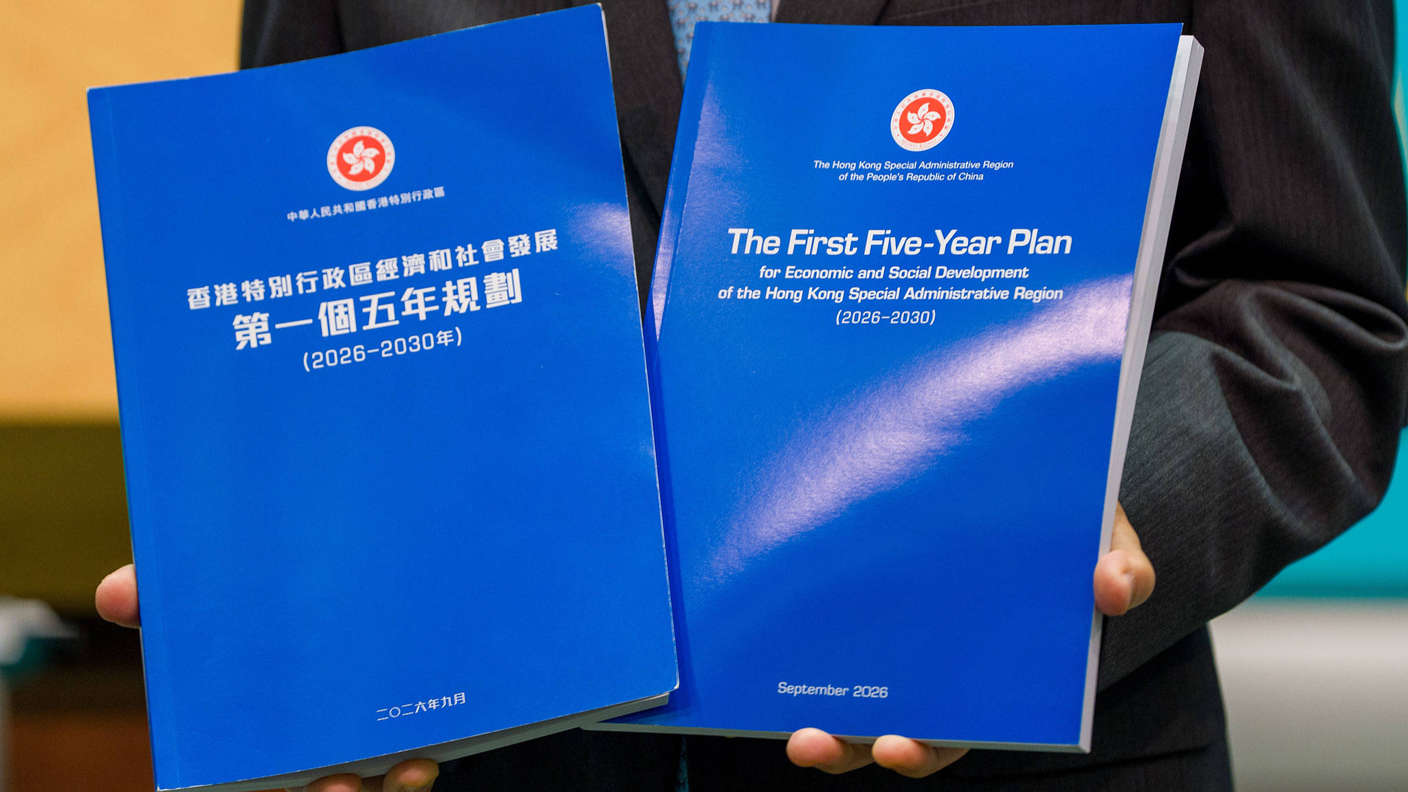 Le directeur général de Hong Kong, John Lee, brandit le livret du plan quinquennal lors d'une conférence de presse avant la réunion de son conseil exécutif le 15 septembre 2026, dans la région administrative spéciale de Hong Kong (RASHK), en Chine. /CFP