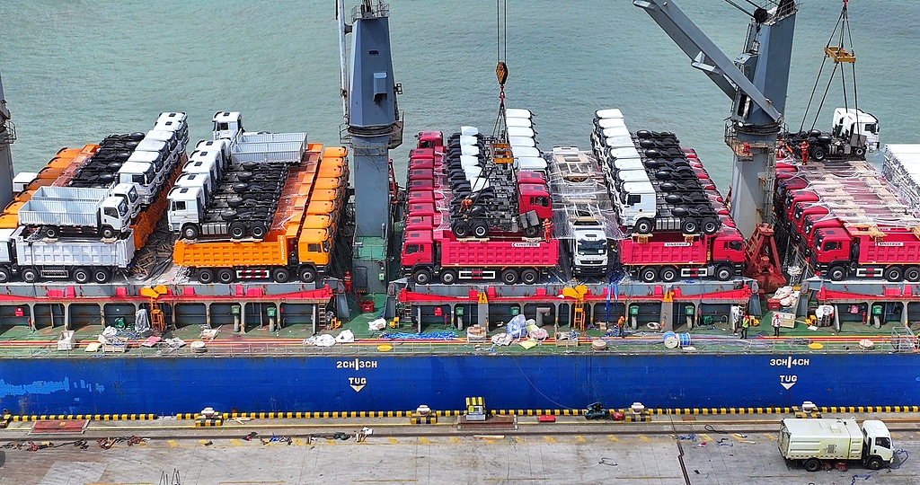 Des ouvriers chargent des véhicules d'ingénierie pour les exporter vers les pays partenaires de la BRI à Zhangjiagang, province du Jiangsu, Chine, le 24 août 2026. /VCG