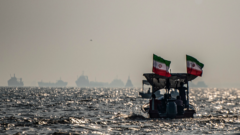 Des navires commerciaux sont ancrés au large alors que de petits bateaux transportant des membres de la force paramilitaire iranienne Basij participent à un exercice militaire le long de la côte iranienne surplombant le détroit d'Ormuz, Iran, le 27 septembre 2026. /VCG