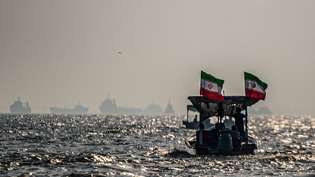 Des navires commerciaux sont ancrés au large alors que de petits bateaux transportant des membres de la force paramilitaire iranienne Basij participent à un exercice militaire le long de la côte iranienne surplombant le détroit d'Ormuz, Iran, le 27 septembre 2026. /VCG
