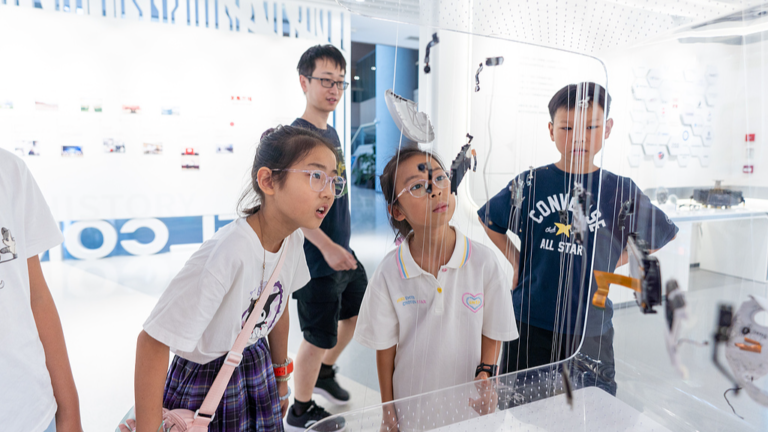 Des élèves du primaire découvrent les matériaux avancés, notamment les alliages flexibles, les céramiques ductiles et les matériaux de fabrication de copeaux, lors d'une visite au laboratoire de Yongjiang à Ningbo, province du Zhejiang, Chine, le 7 juillet 2026. /VCG