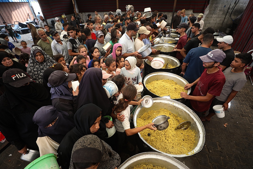 Des Palestiniens, dont des enfants portant des marmites, se rassemblent pour recevoir des repas chauds distribués dans le camp de réfugiés de Nuseirat, dans la ville de Gaza, Gaza, Palestine, le 28 septembre 2026. /VCG