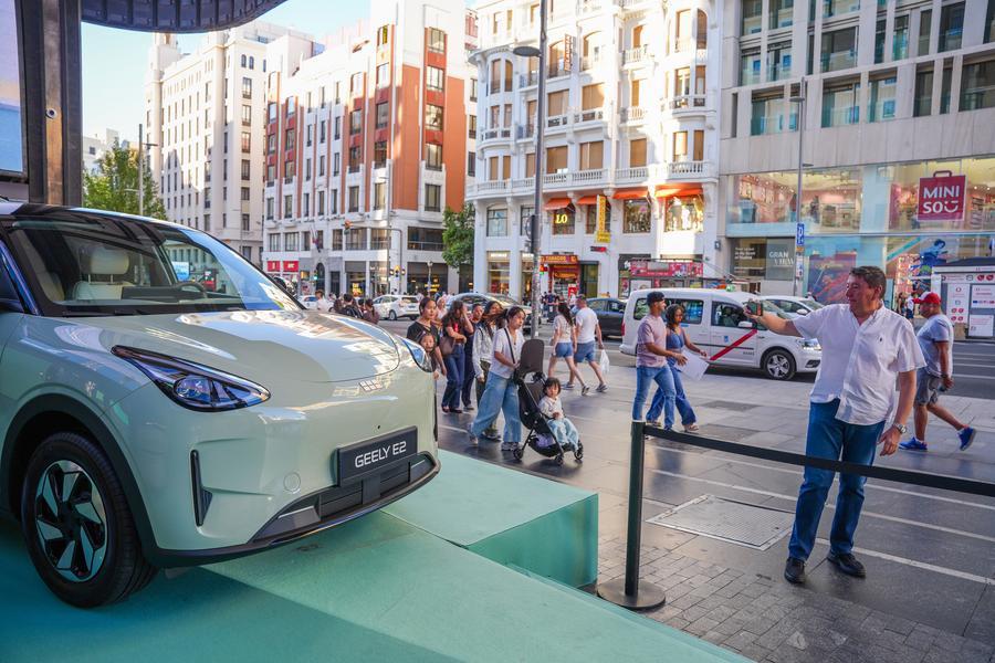 Un homme prend des photos d'un véhicule électrique Geely E2 de fabrication chinoise sur la Gran Vía à Madrid, en Espagne, le 9 septembre 2026. /Xinhua