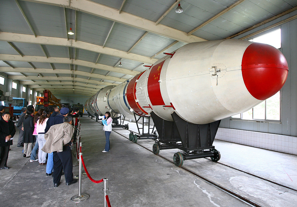 Les visiteurs admirent la fusée porteuse Longue Marche-3 dans le hall d'exposition du Centre de lancement de satellites de Xichang à Liangshan, province du Sichuan, le 20 octobre 2007. /VCG