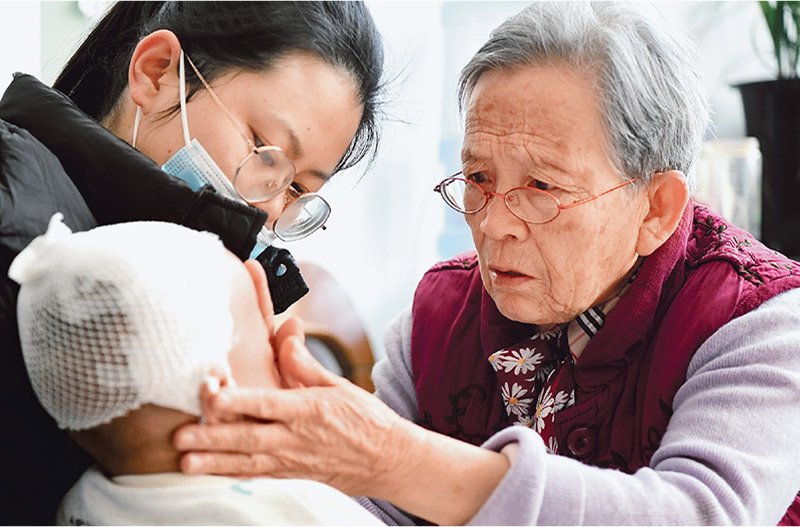 Lu Shengmei (à droite) offre une consultation médicale gratuite à un enfant à son domicile du comté de Jiaxian, Yulin, province du Shaanxi, le 16 novembre 2022. /Xinhua