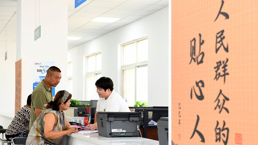 Un membre du personnel aide les résidents à demander une aide gouvernementale pour les ménages à faible revenu dans un centre de services du Parti de la municipalité de Xiangzhaozhuang, comté de Xiajin, ville de Dezhou, province du Shandong (est de la Chine), le 5 juillet 2026. /Xinhua