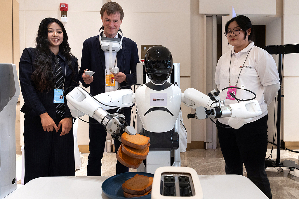 Un participant teste un robot lors du Forum sur la gouvernance mondiale 2026, à Xiongan, province du Hebei, Chine, le 23 octobre 2026. /VCG
