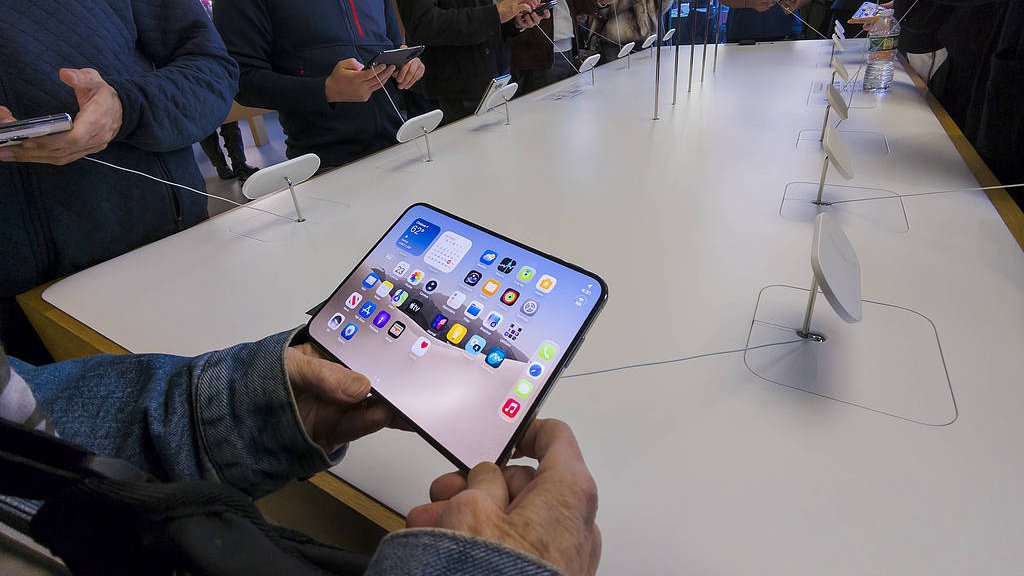 Des clients parcourent le nouveau smartphone pliable Apple iPhone Duo dans l'Apple Store du quartier Meatpacking à New York, États-Unis, le 23 octobre 2026. /VCG