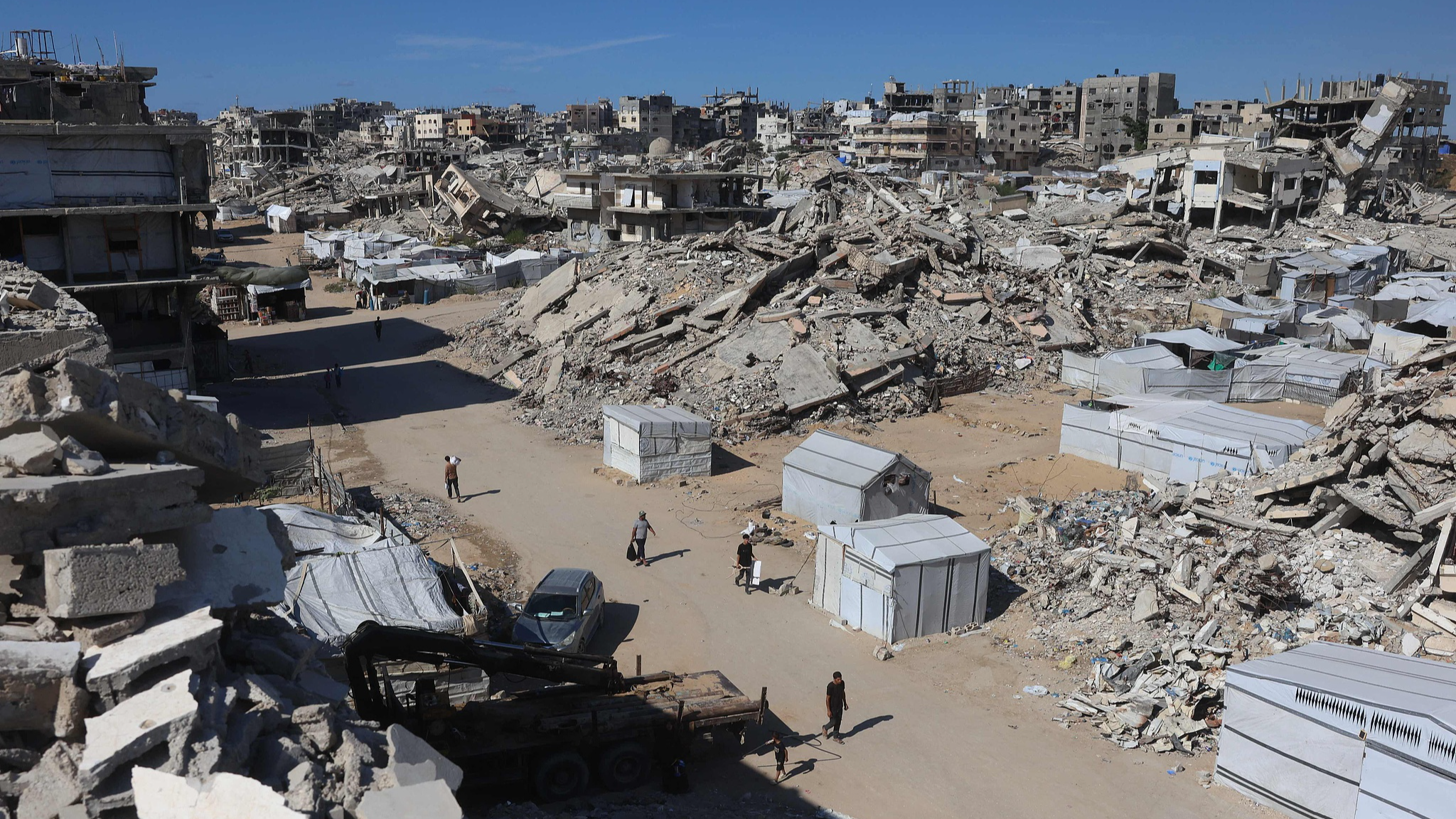 Des Palestiniens passent devant des bâtiments détruits et des abris de fortune dans le camp de réfugiés de Jabalia, dans le nord de la bande de Gaza, le 5 octobre 2026. /VCG