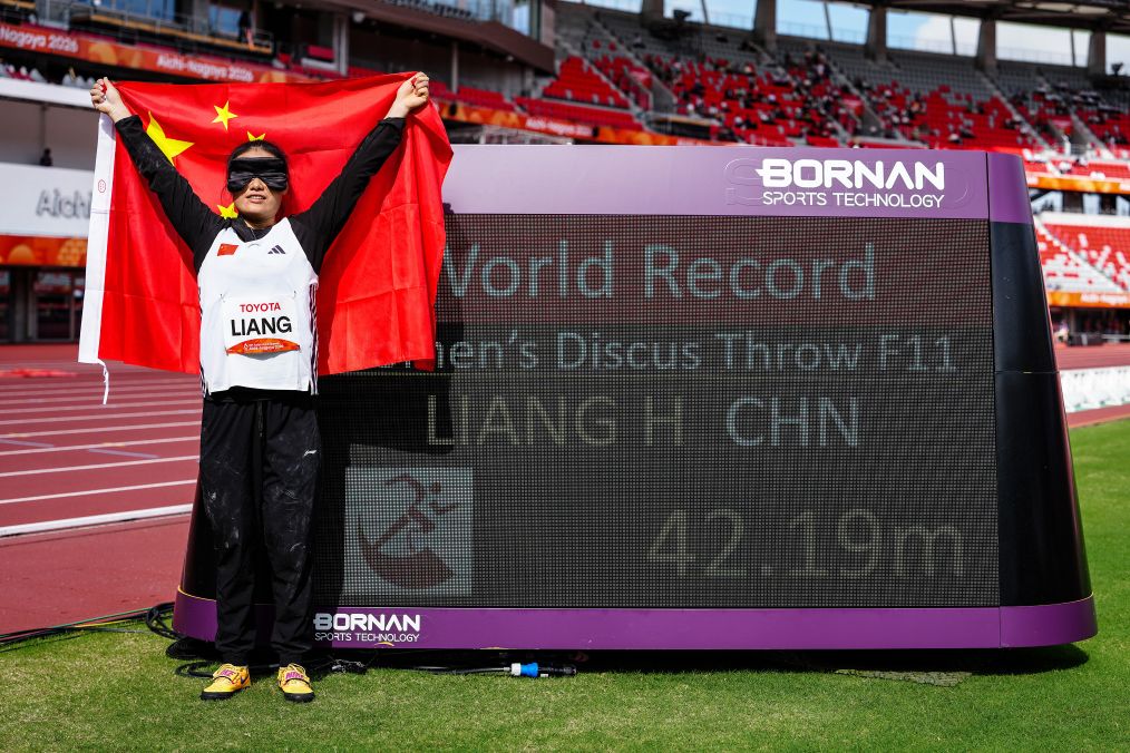La Chinoise Liang Hongxia pose devant un tableau affichant son nouveau record du monde de 42,19 mètres après avoir remporté la médaille d'or du disque F11 féminin aux Jeux para-asiatiques d'Aichi-Nagoya 2026 à Nagoya, au Japon, le 21 octobre 2026. /Xinhua