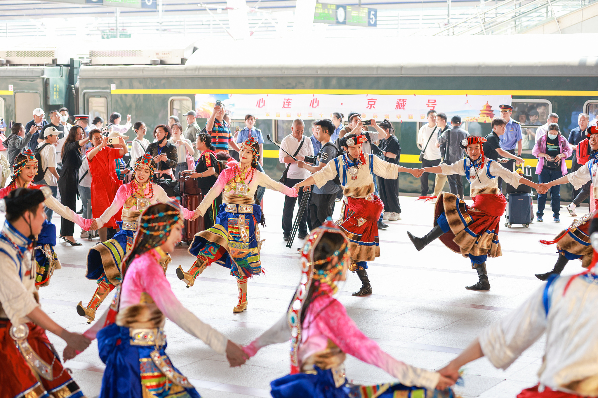 Des danseurs exécutent une danse traditionnelle en tenue traditionnelle tibétaine alors qu'un train touristique reliant Pékin à la région autonome de Xizang part de la gare de l'Ouest de Pékin, en Chine, le 19 mai 2024. /CFP