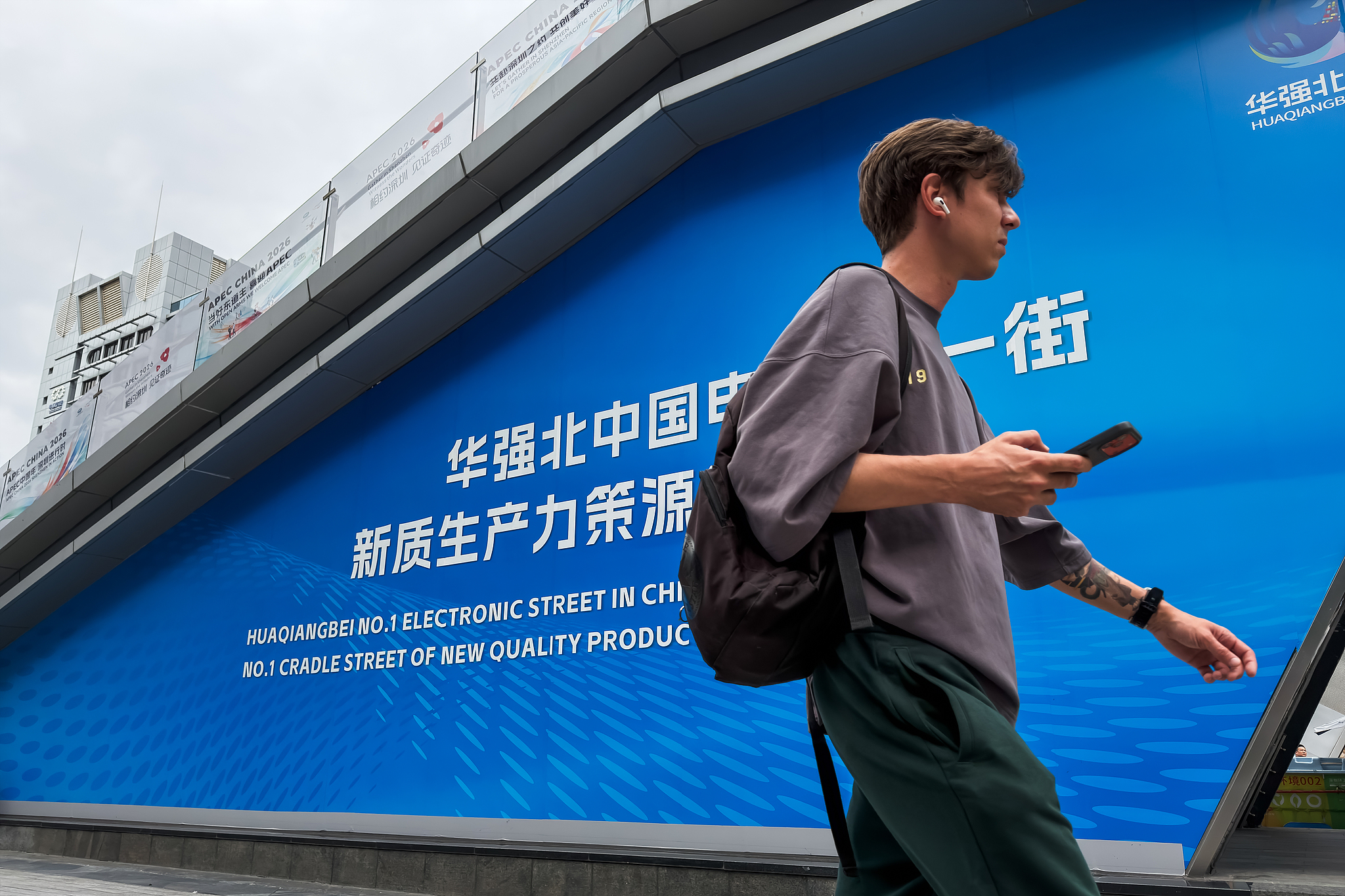 Un visiteur étranger passe devant la signalisation du marché du district électronique de Huaqiangbei, à Shenzhen, province du Guangdong, Chine du sud, le 3 septembre 2026. /VCG
