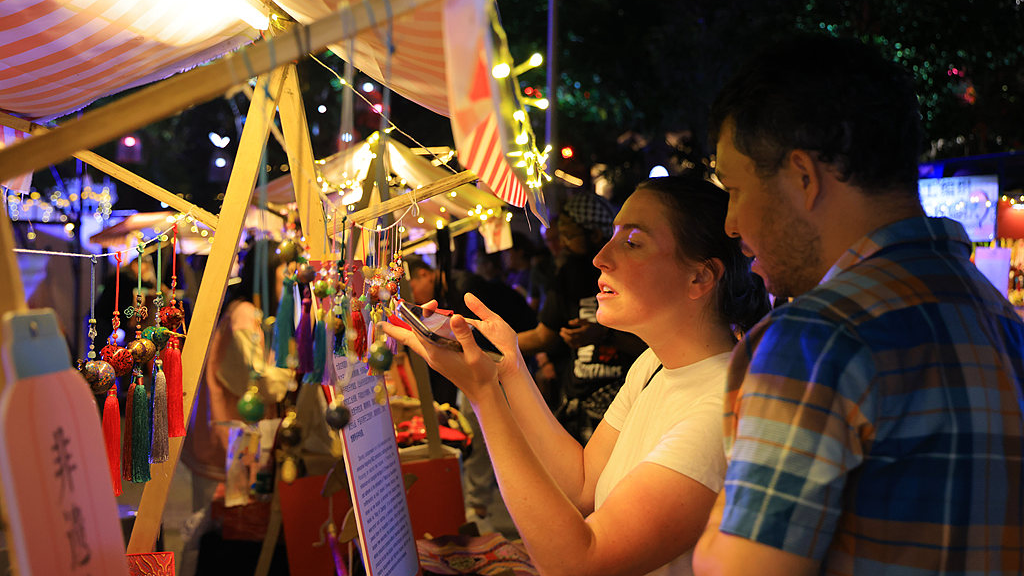 Des touristes internationaux parcourent un marché de la fête de la mi-automne au parc culturel et touristique de Suoxi à Zhangjiajie, province du Hunan, centre de la Chine, le 23 septembre 2026. /VCG