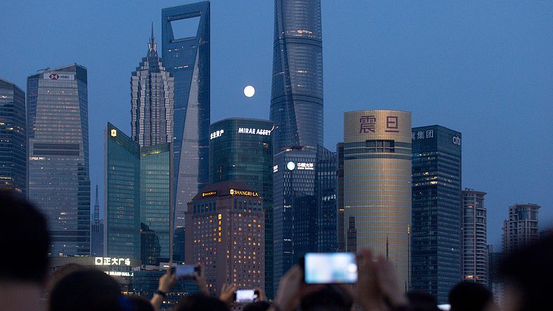 Une pleine lune s'est levée lentement entre les bâtiments de Lujiazui, Shanghai, attirant un grand nombre de touristes pour prendre des photos et s'enregistrer, Shanghai, Chine, 25 septembre 2026./VCG