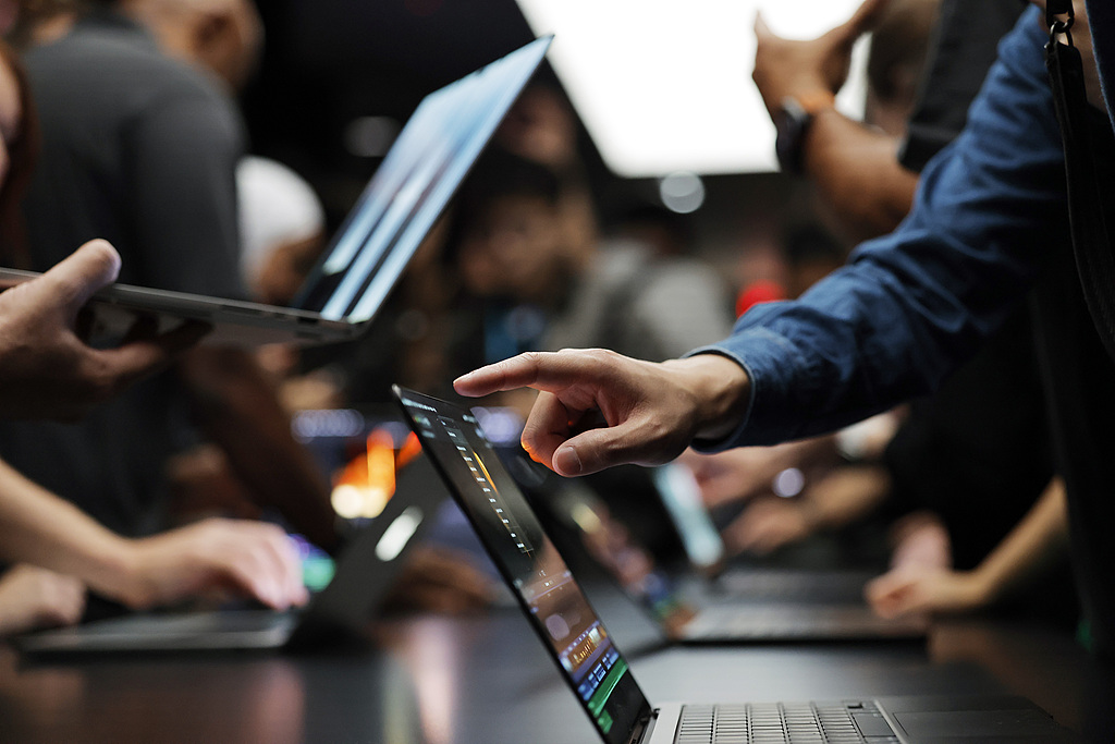 Les participants essaient le nouveau MacBook Pro à écran tactile chez Apple