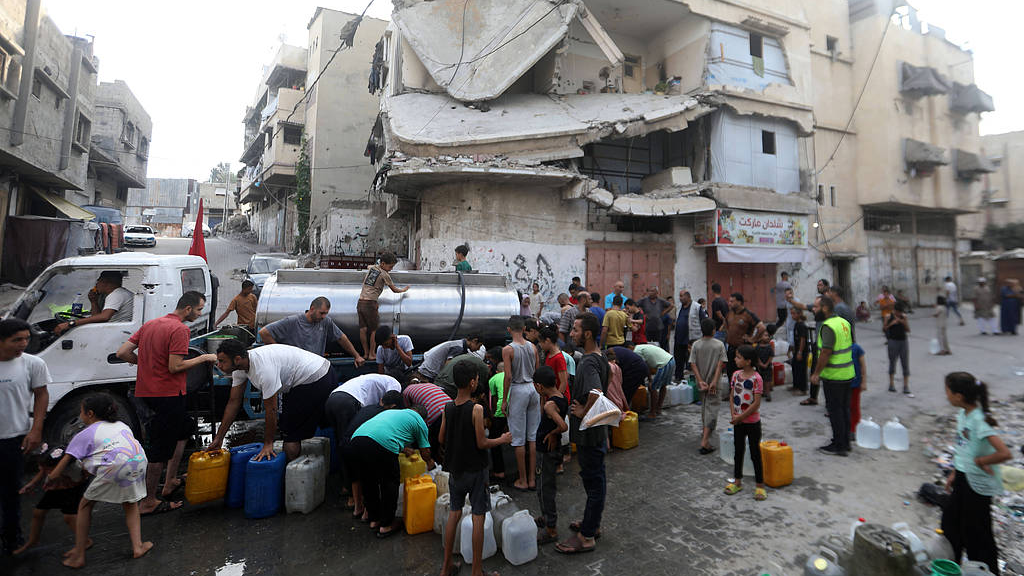Des Palestiniens déplacés se rassemblent pour récupérer de l'eau gratuite dans un camion de distribution près de la Ligne jaune à l'est de la ville de Gaza, Gaza, Palestine, le 18 août 2026. /VCG